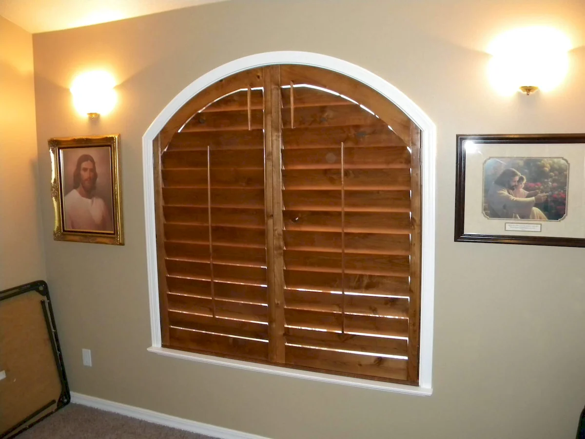 bedroom with inside custom plantation shutters made of wood