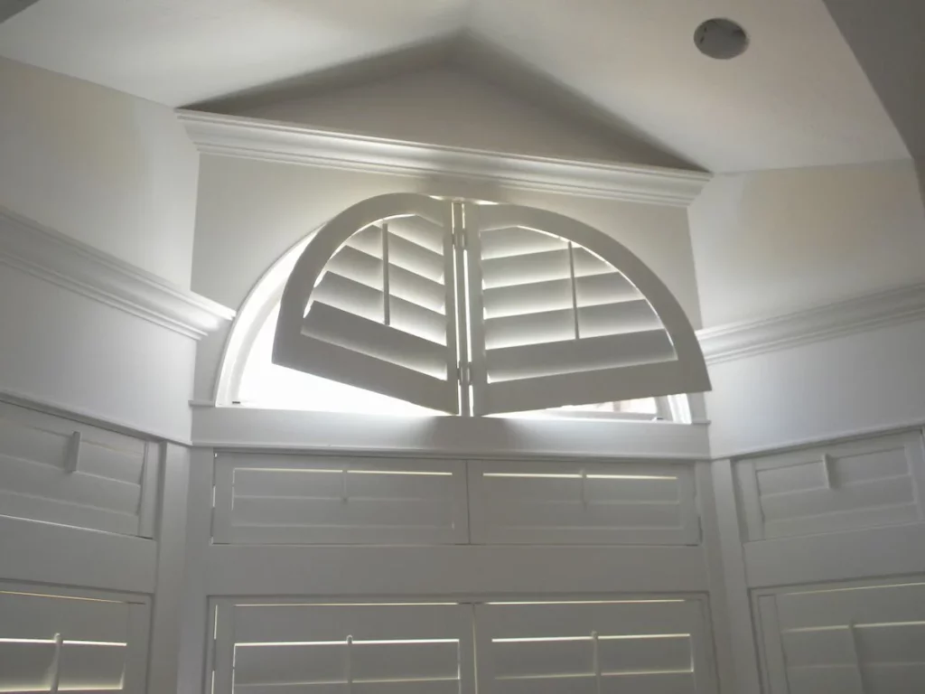 bedroom with indoor custom plantation shutters made of wood