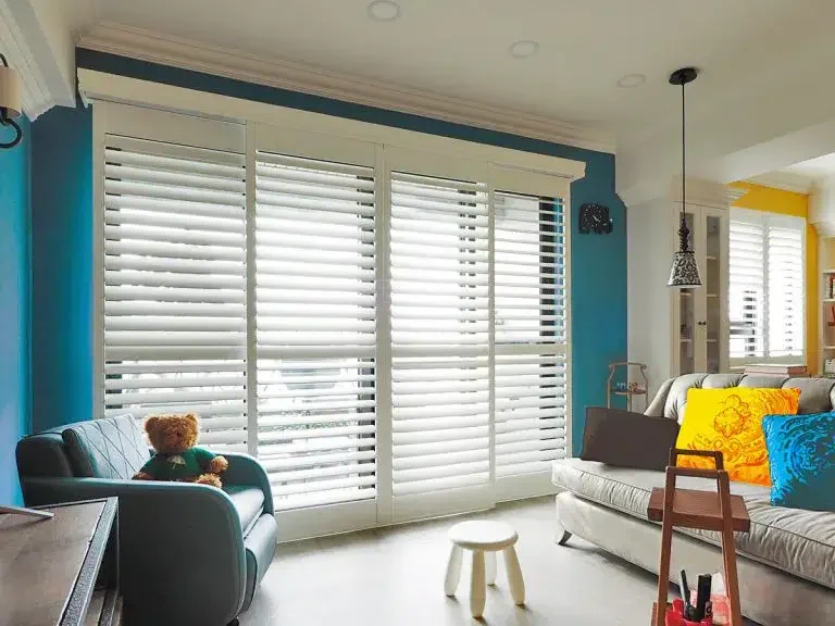 living room with full-height bi-fold inside custom plantation shutters made of wood